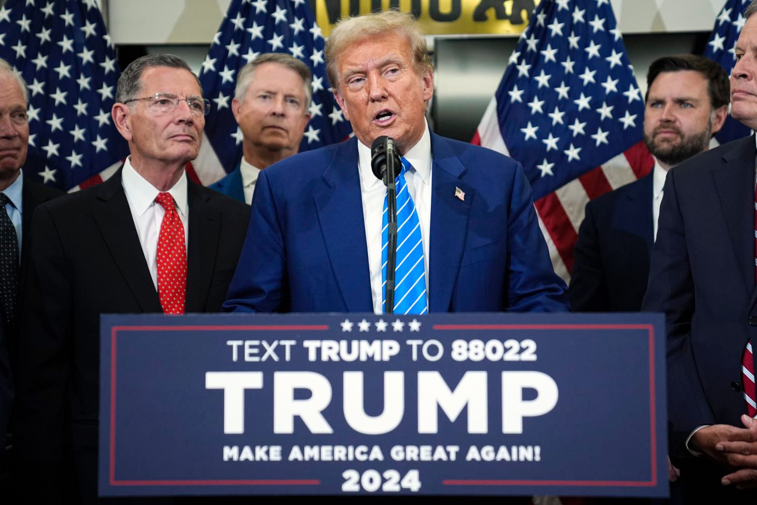 Former President Donald Trump speaks behind bullet-resistant glass during a campaign event at Central Wisconsin Airport on Saturday, September 7, 2024.