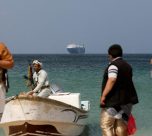File Photo: Armed Men Stand On The Beach As The Galaxy Leader Commercial Ship, Seized By Yemen's Houthis Last Month, Is Anchored Off The Coast Of Al Salif