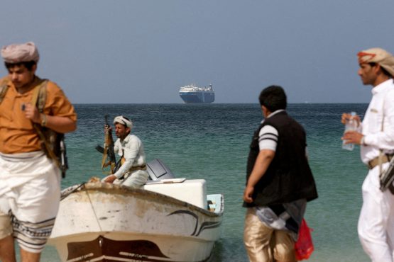 File Photo: Armed Men Stand On The Beach As The Galaxy Leader Commercial Ship, Seized By Yemen's Houthis Last Month, Is Anchored Off The Coast Of Al Salif